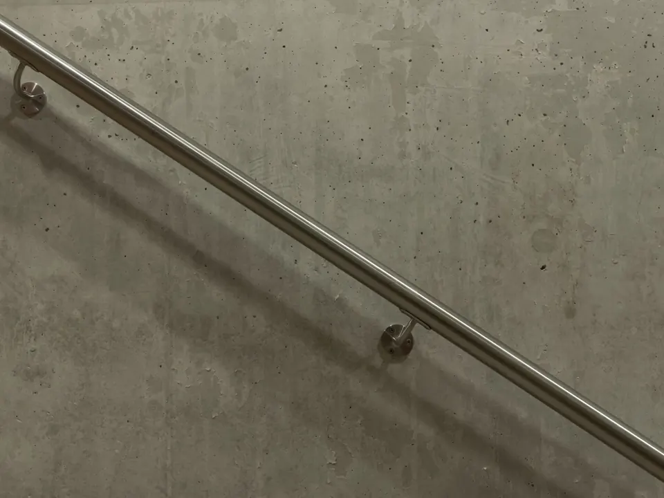 Main courante en inox fixée sur un mur en béton