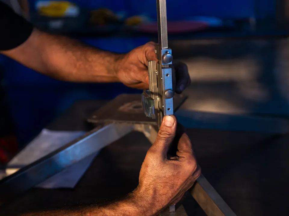 Mains contrôlant l'équerrage d'une tôle pliée